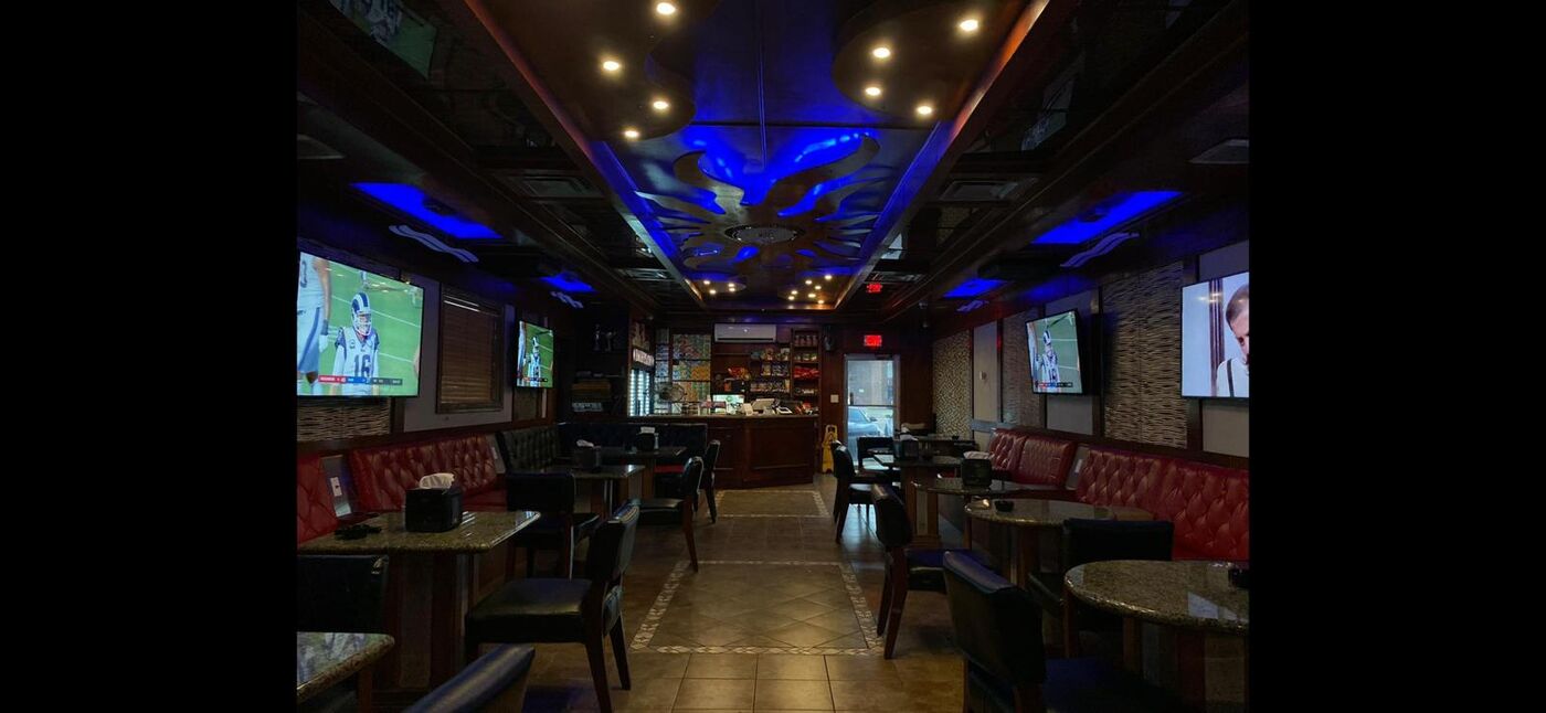 Babylon Hookah Lounge interior with blue ceiling lighting and red booths